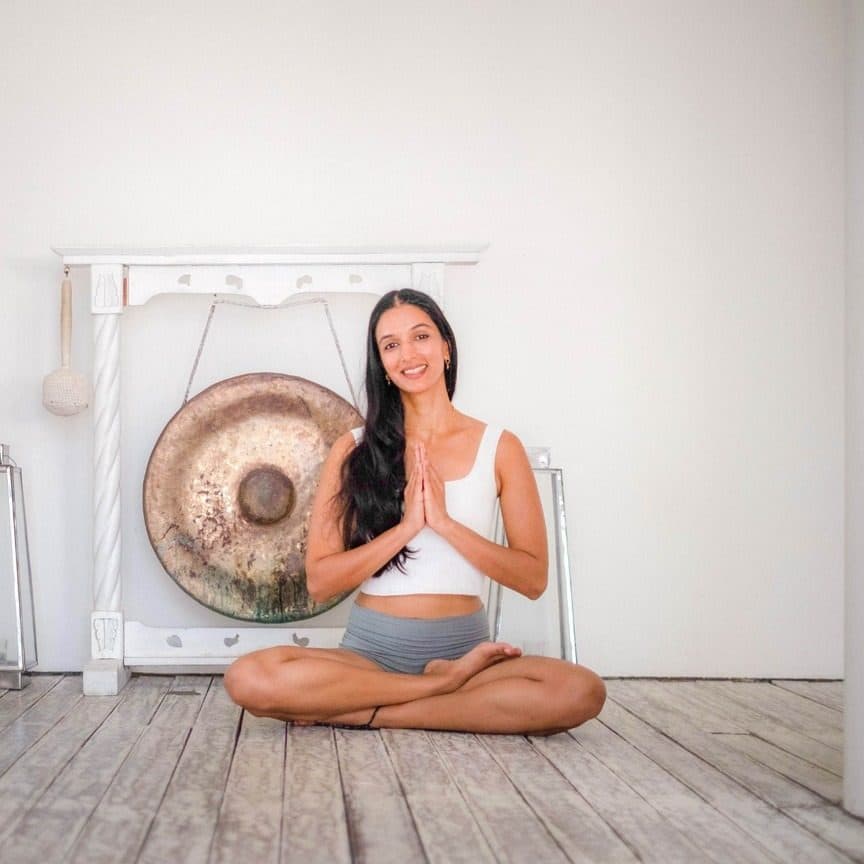 Ira Trivedi seated before a gong