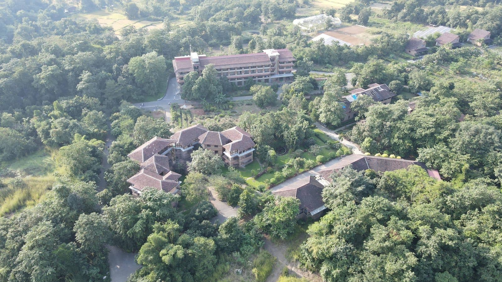Govardhan Eco Village from the air, buildings among forest