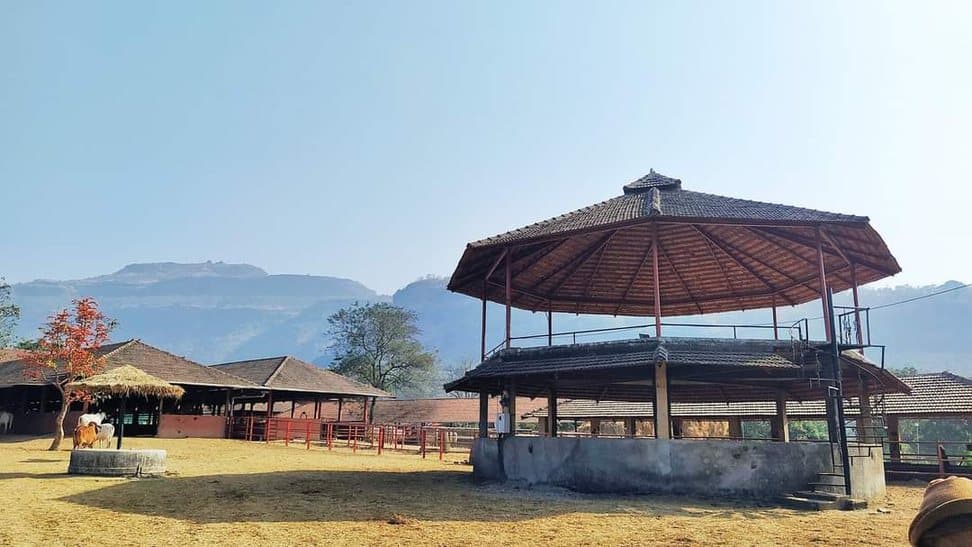 An open pavilion on the lawns, with the Sahyadri hills behind
