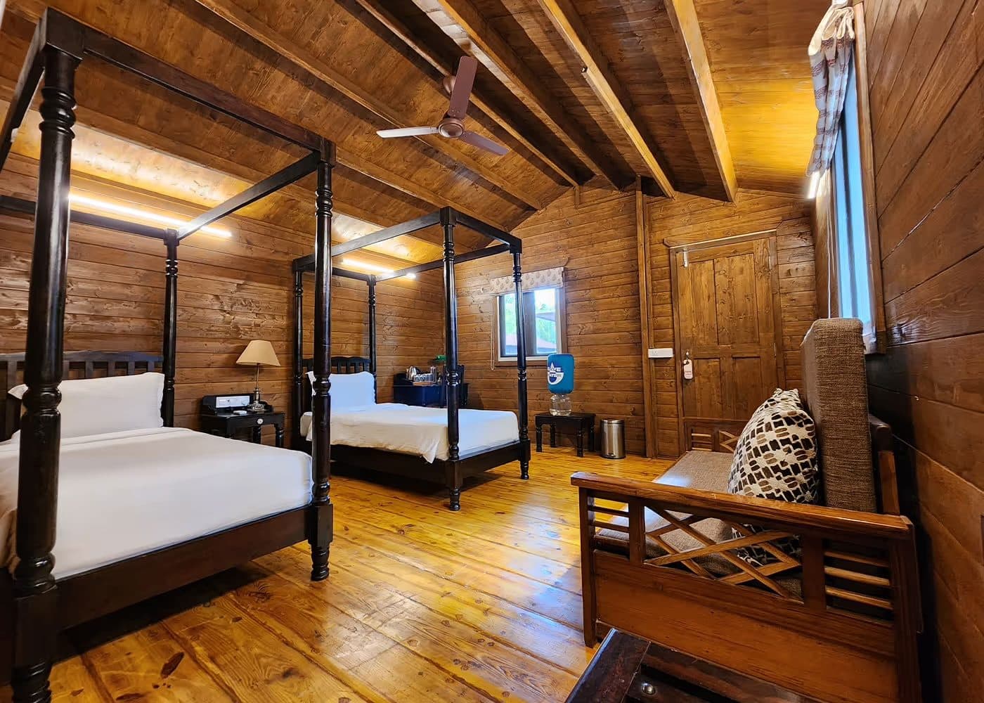 A Mahavan room with twin four-poster beds and wooden floors