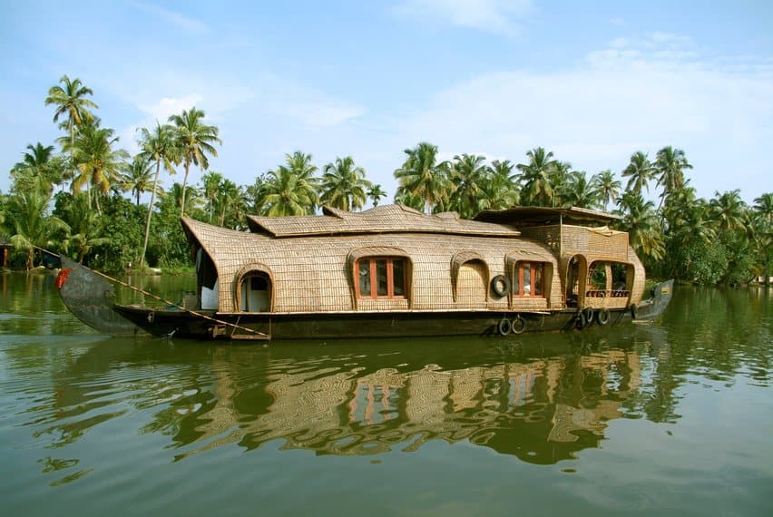 A Kerala houseboat on the backwaters, lined with coconut palms