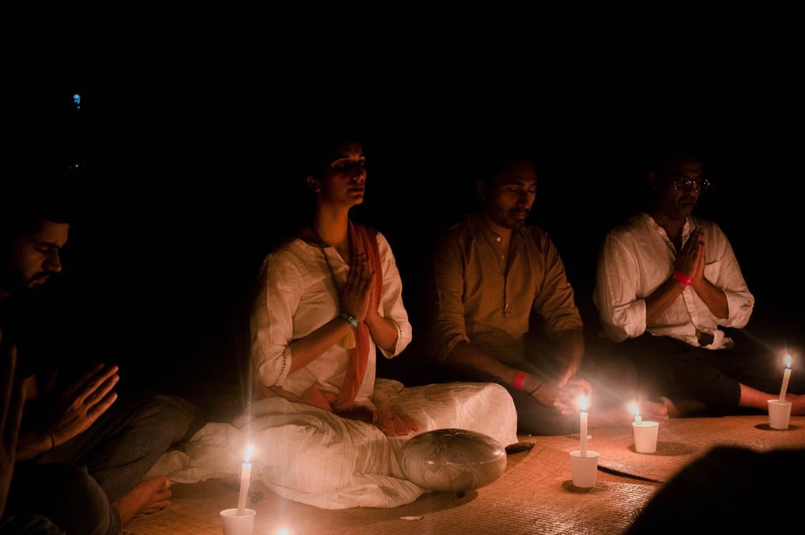 Guests in candlelit meditation