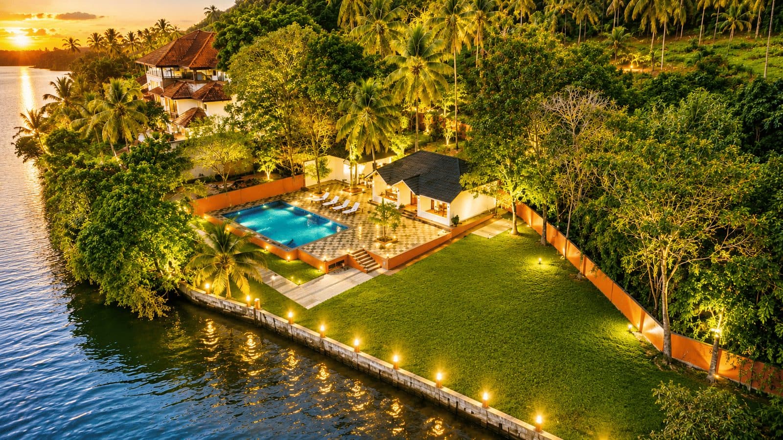 The resort from the air at dusk, pool and lawns beside the water