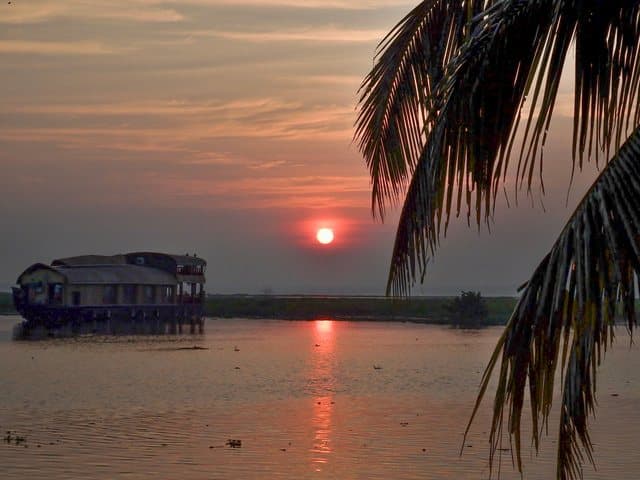Sunset over the backwaters, a houseboat in silhouette